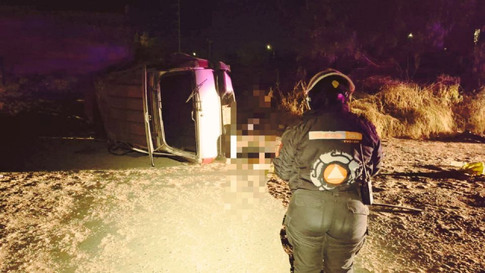 Autoridades de Pesquería resguardan la zona del accidente donde una mujer murió y otra resultó lesionada tras la volcadura de una camioneta.