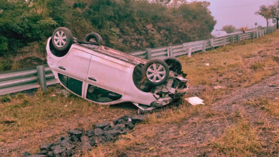 Uno de los vehículos involucrados quedó volcado a un costado de la Carretera Nacional, tras perder el control por el pavimento resbaladizo.