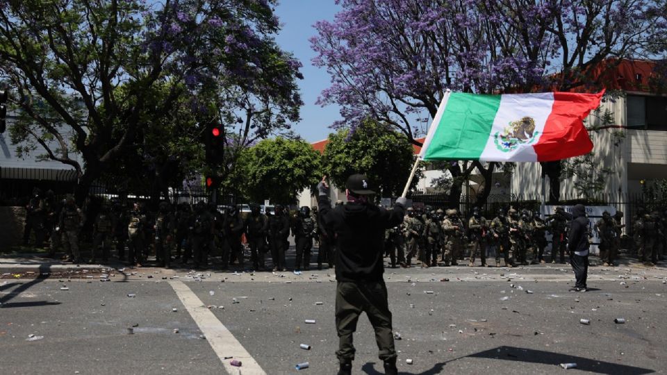 Fotografía del 7 de junio de una manifestante sosteniendo una bandera mexicana durante una protesta contra las redadas del Servicio de Inmigración y Control de Aduanas (ICE) en Paramount.