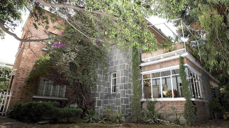 Hay una sala estilo colonial con sillones de antebrazos de madera.
