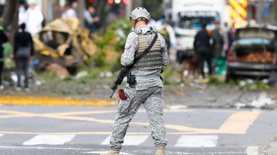 Un integrante de la Fuerza Aérea custodia la zona del atentado tras una explosión en Cali.