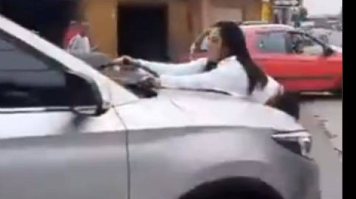 VIDEO: Encontró a su pareja con otra mujer y se avalanzó sobre el carro en plena calle
