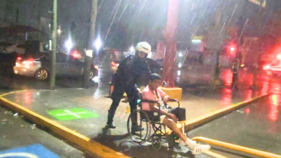 El oficial Daniel Arriazola de la Policía de Guadalupe resguardó a un hombre en silla de ruedas durante la lluvia en la colonia 21 de Enero.