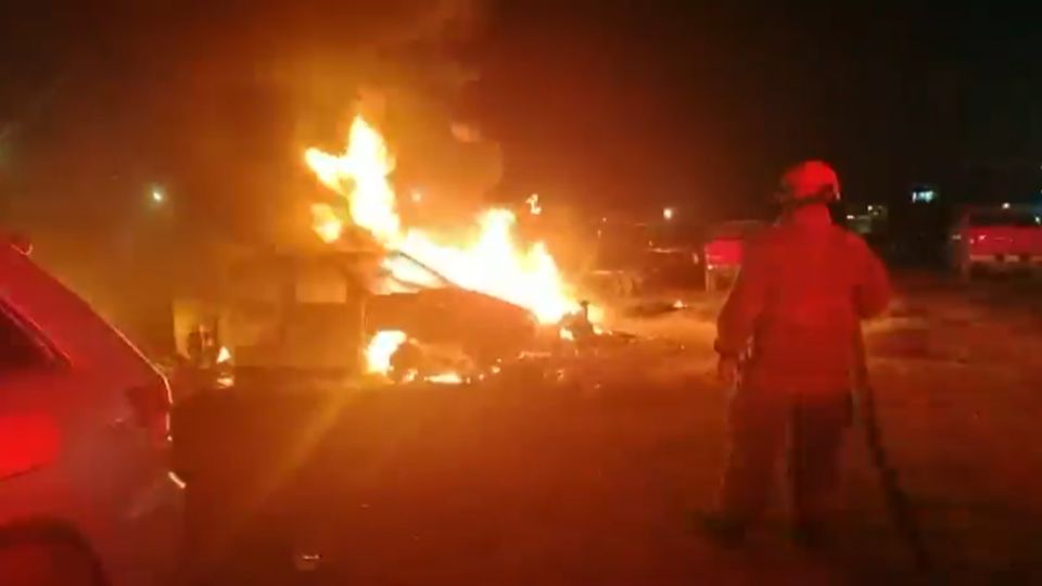 Bomberos y cuerpos de auxilio trabajaron durante la madrugada para sofocar el incendio que destruyó cuatro camionetas en un yonke de Escobedo.