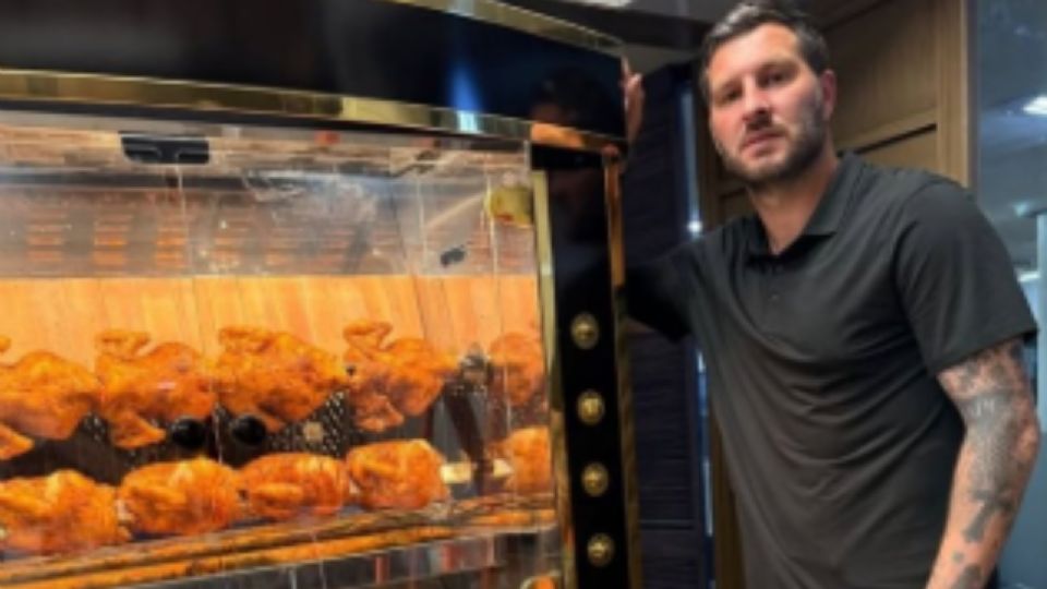André-Pierre Gignac posa junto a un pollo rostizado dorado y una pizza artesanal en la futura cocina de ‘Petite Canaille’, su nuevo restaurante en Centrito Valle, San Pedro.
