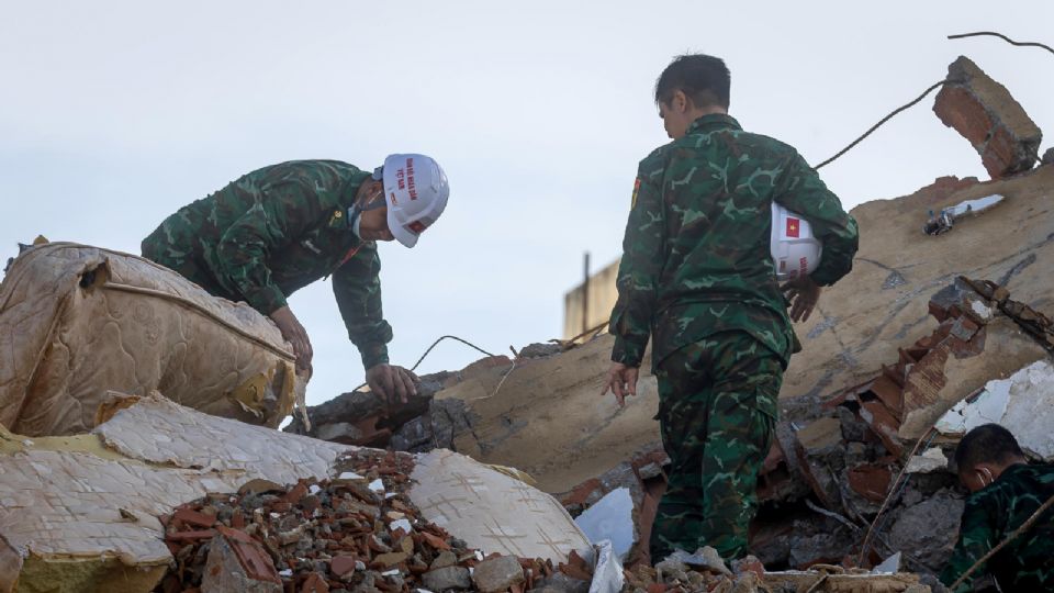 Rescatistas de Vietnam caminan este martes sobre escombros de edificaciones destruidas en Catia La Mar, La Guaira.